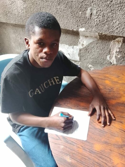 Emmanuel, élève parrainé par MONIELO, à une table de travail